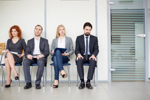 Portrait of several business associates sitting on chairs by office door