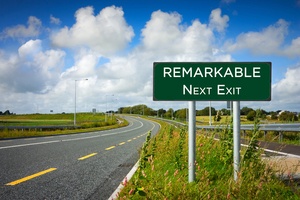 road with sign reading remarkable take the next exit